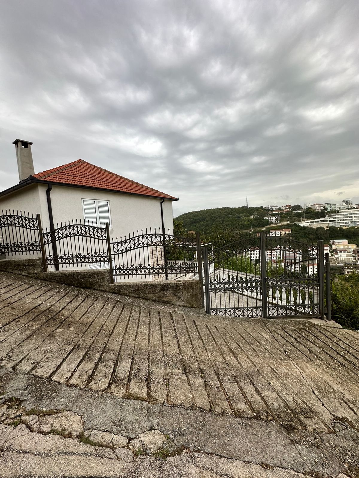 Investment opportunity in Ulcinj: Modern home with red-tile roof, fenced yard, driveway, and panoramic views. Montenegro-listings.me by ekosphere doo.