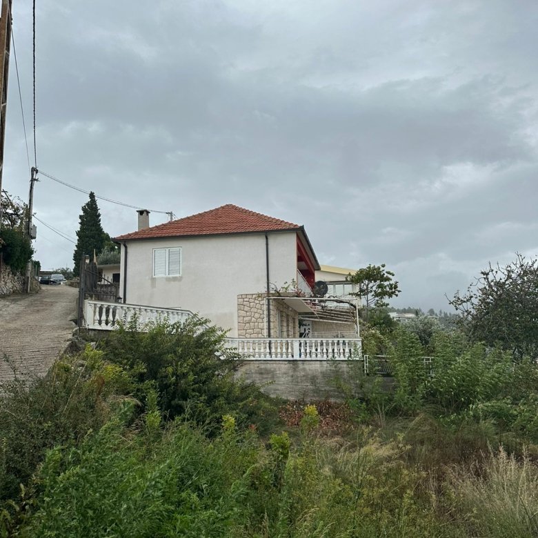 Exclusive two-story home with red roof, lush greenery, and stone balustrade in Ulcinj&mdash;prime investment via immorenta.me.