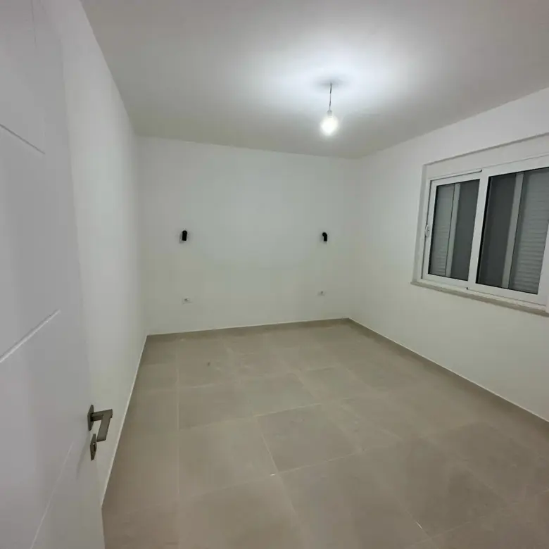 Modern, sunlit room in Ulcinj, Montenegro&mdash;ideal investment. White walls, tiled floor, window. Exclusive on immorenta.me by Ekosphere doo.