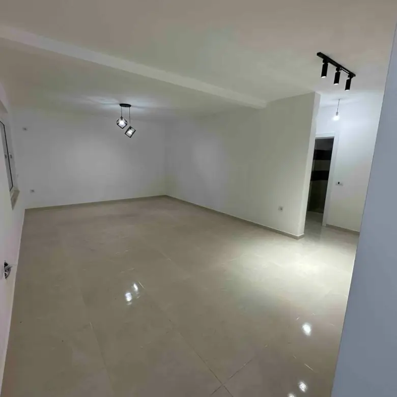 Modern, sunlit room with glossy beige tiles and white walls&mdash;prime Ulcinj property for sale on immorenta.me by ekosphere doo.