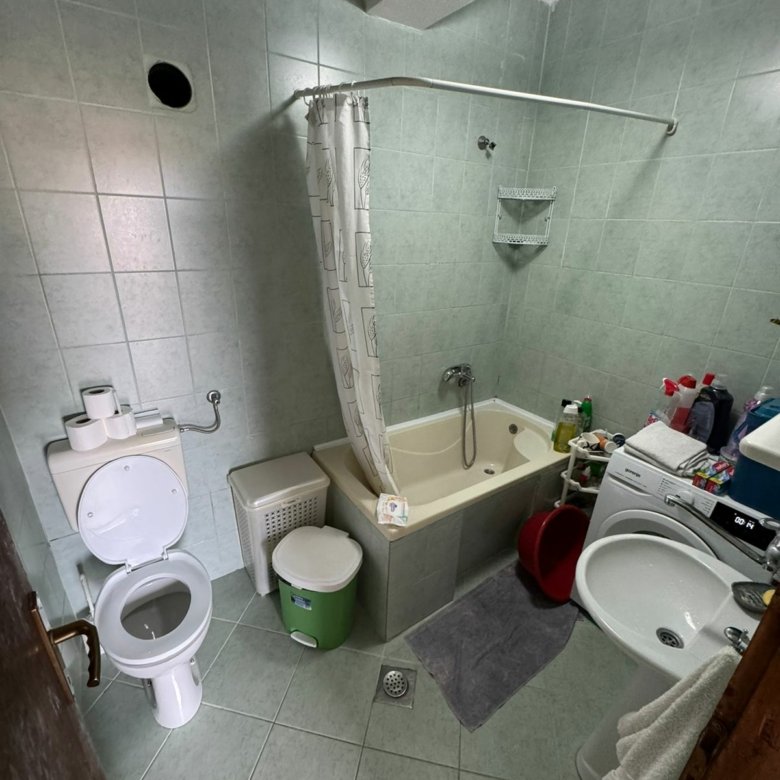 Modern Ulcinj bathroom with green tiles, tub, washer & amenities&mdash;ideal Montenegro investment. View at immorenta.me by ekosphere doo.