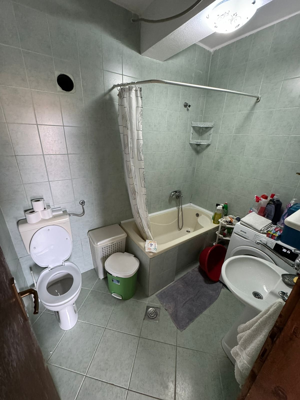 Modern Ulcinj bathroom with green tiles, tub, washer & amenities&mdash;ideal Montenegro investment. View at immorenta.me by ekosphere doo.