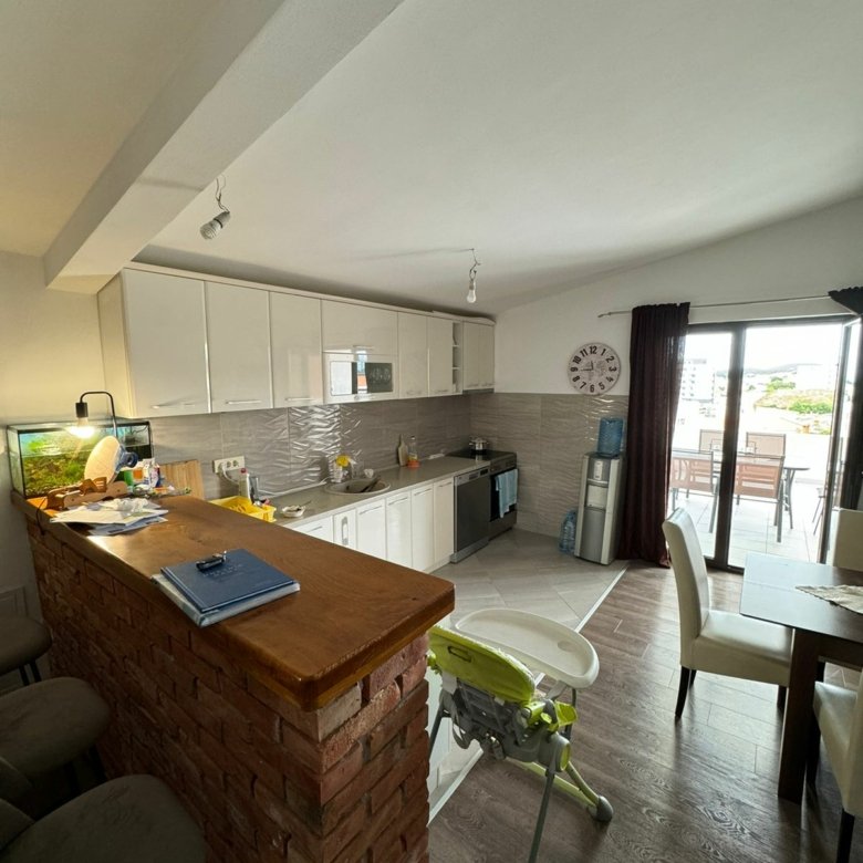 Stylish modern kitchen in Ulcinj with white cabinets, wooden floors, and brick bar&mdash;exclusive at immorenta.me by ekosphere doo.