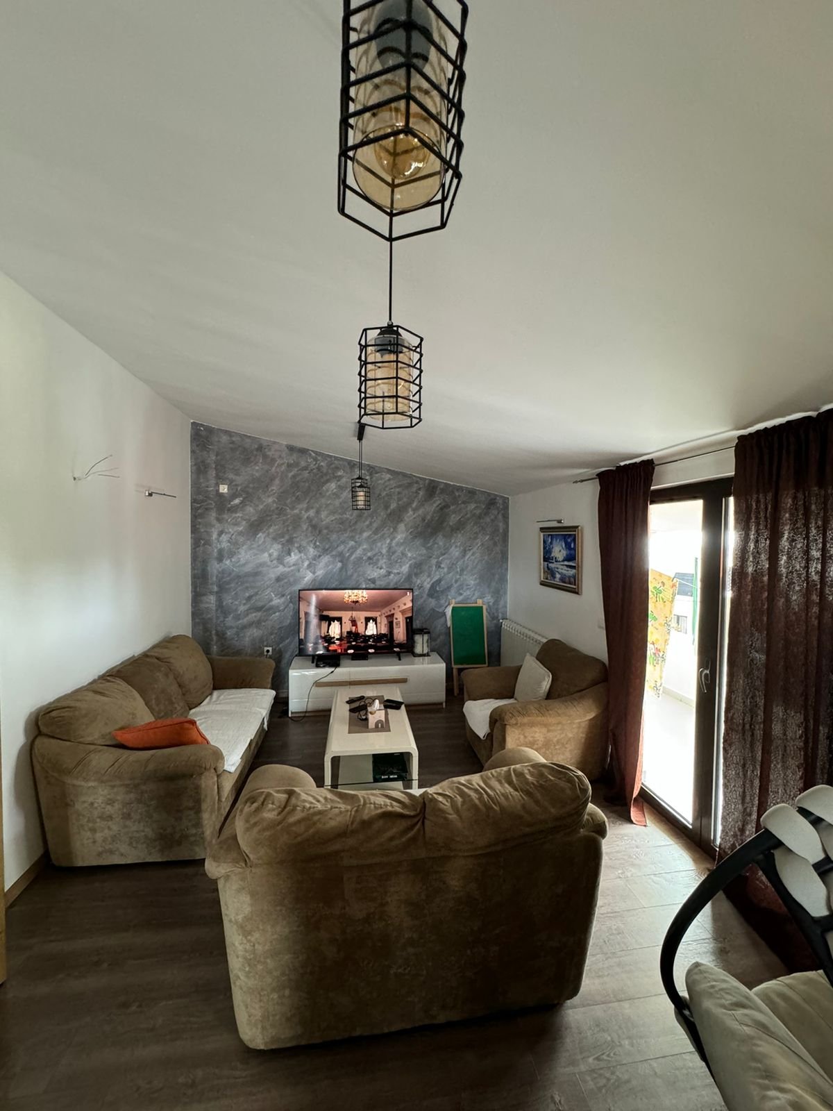 Luxurious Ulcinj Montenegro living room with beige sofas, fireplace, and sunlit glass doors; top investment via immorenta.me.