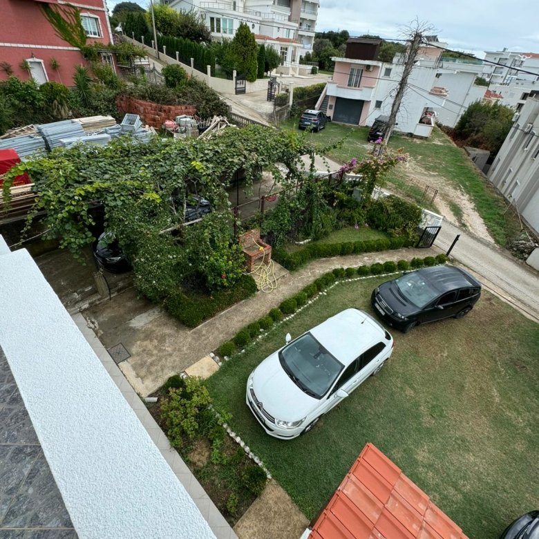 Aerial view of Ulcinj garden plot with pergola, cars, and nearby properties&mdash;prime real estate at immorenta.me by Ekosphere.