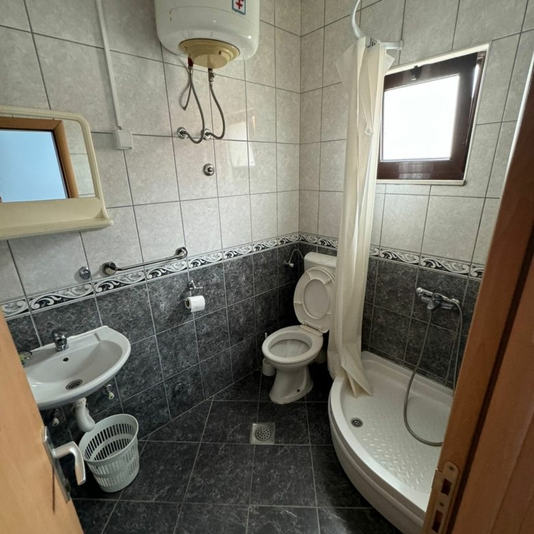 Modern small bathroom in Ulcinj, Montenegro property&mdash;gray tiles, compact shower, wall sink; on immorenta.me by Ekosphere doo.