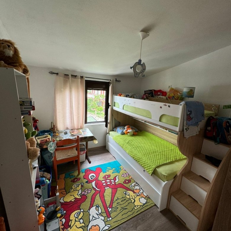 Bright, inviting kids&rsquo; room in Ulcinj features bunk bed, playful rugs, and natural light&mdash;prime real estate by ekosphere doo.