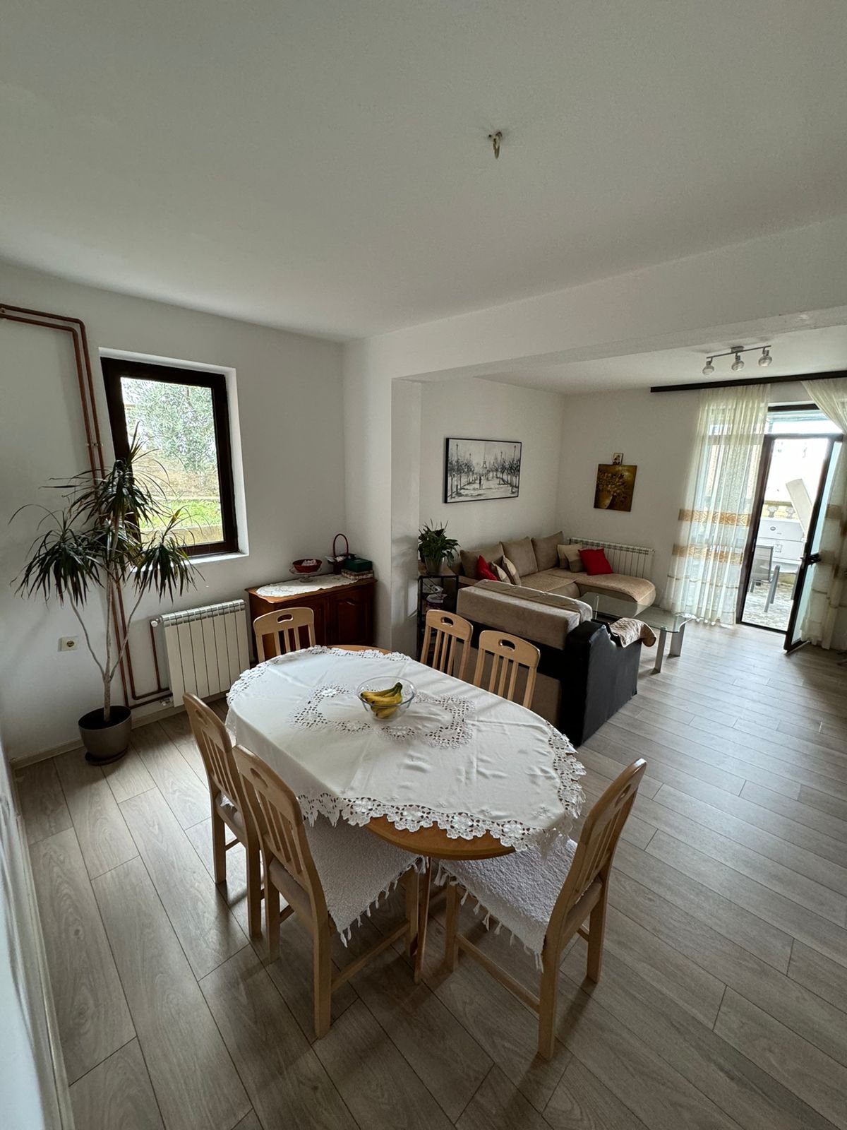 Elegant dining and living room in Ulcinj with wood flooring, bright windows, and premium finishes. Invest with immorenta.me by ekosphere.