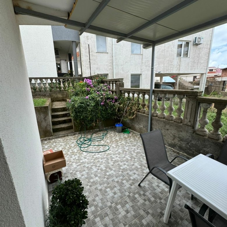 Elegant covered patio with tiled floors, garden views, ideal for investing in Ulcinj real estate at immorenta.me by Ekosphere doo.