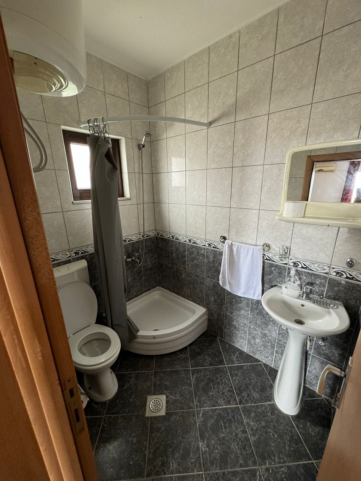 Modern tiled bathroom in Ulcinj real estate, with corner shower, quality fittings; ideal investment via immorenta.me by ekosphere doo.