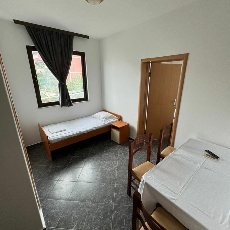 Cozy room for sale in Ulcinj, Montenegro: single bed, table, and chairs. Ideal investment via immorenta.me by ekosphere doo.
