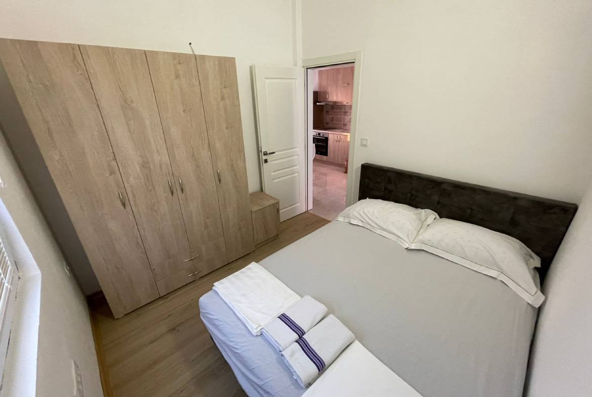 Charming Ulcinj Montenegro property: stylish small bedroom with wood floors, double bed, wardrobe&mdash;ideal investment at immorenta.me by ekosphere doo.