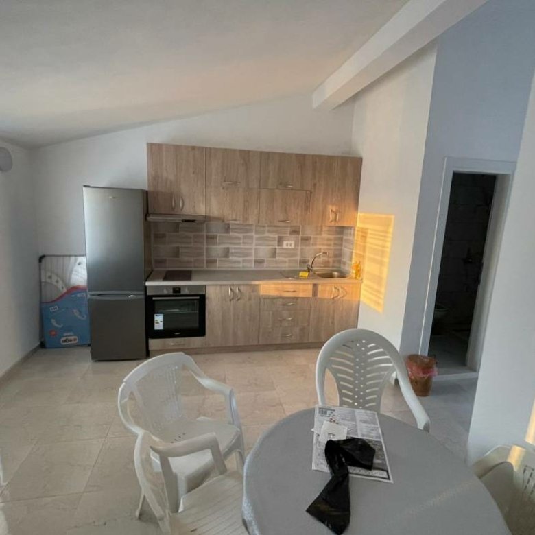 Modern sunlit kitchen in Ulcinj with wood cabinets, stainless appliances, ideal for Montenegro property buyers. Eksophere doo project.