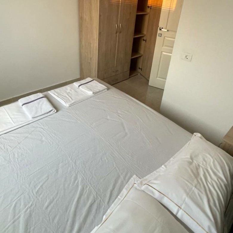 Bright, minimal Ulcinj bedroom with a neat bed, wardrobe, and closet&mdash;exclusive on immorenta.me by ekosphere doo.