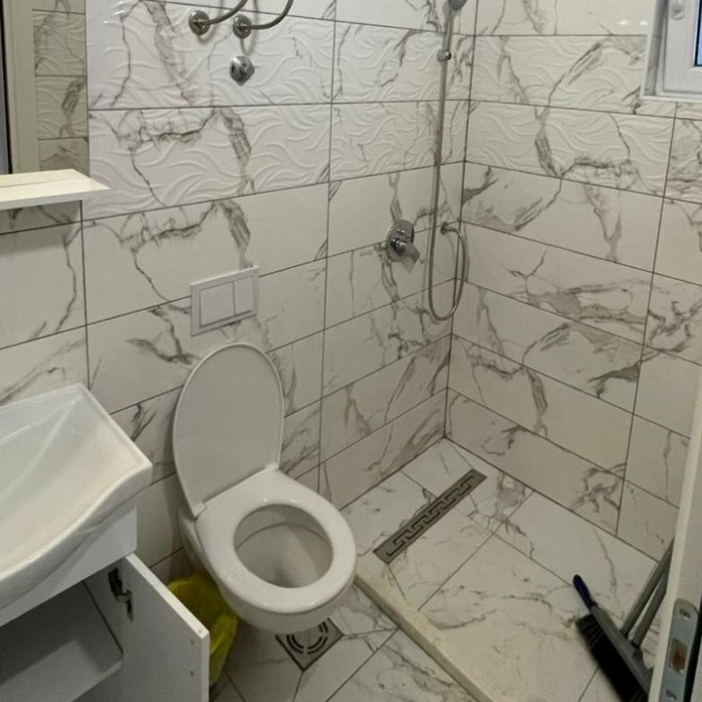 Modern small bathroom in Ulcinj property with marble tiles, walk-in shower; invest via immorenta.me by ekosphere doo.