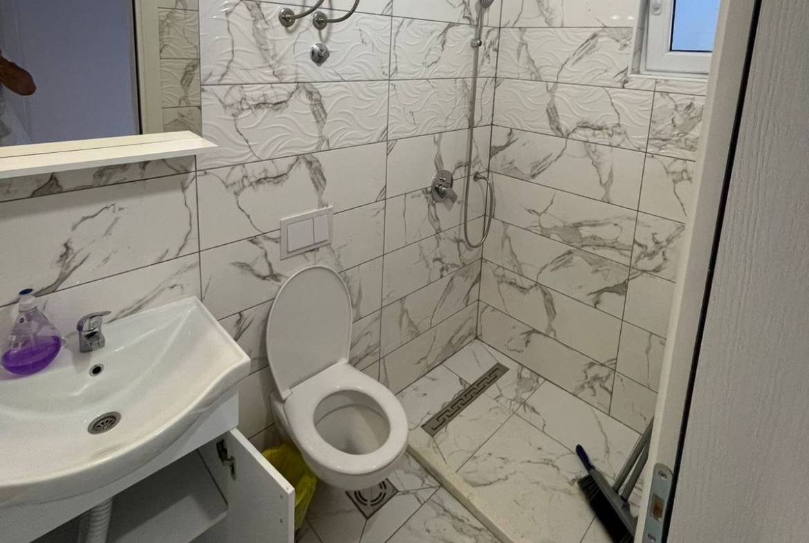 Modern small bathroom in Ulcinj property with marble tiles, walk-in shower; invest via immorenta.me by ekosphere doo.