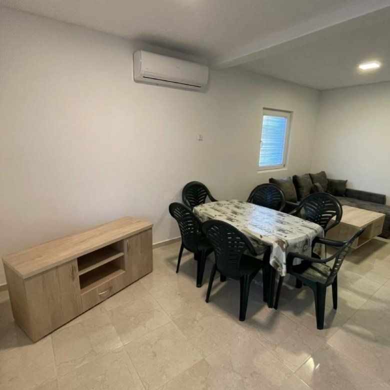 Modern open-plan living/dining in Ulcinj, Montenegro: tiled floors, gray sofa, AC&mdash;prime investment at immorenta.me by ekosphere doo.