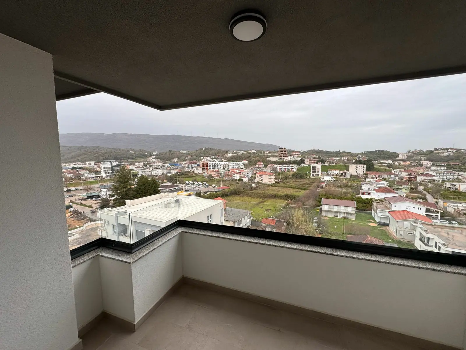 Stunning Ulcinj, Montenegro balcony view: prime real estate, lush hills, modern homes. Explore ekosphere&rsquo;s listings at Montenegro-Listings.me.