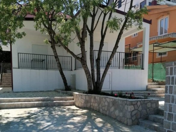 Modernes wei&szlig;es Grundst&uuml;ck mit schwarzem Gel&auml;nder, Pflanzgef&auml;&szlig;en aus Stein und B&auml;umen in Ulcinj. Exklusiv auf immorenta.me von ekosphere doo. 