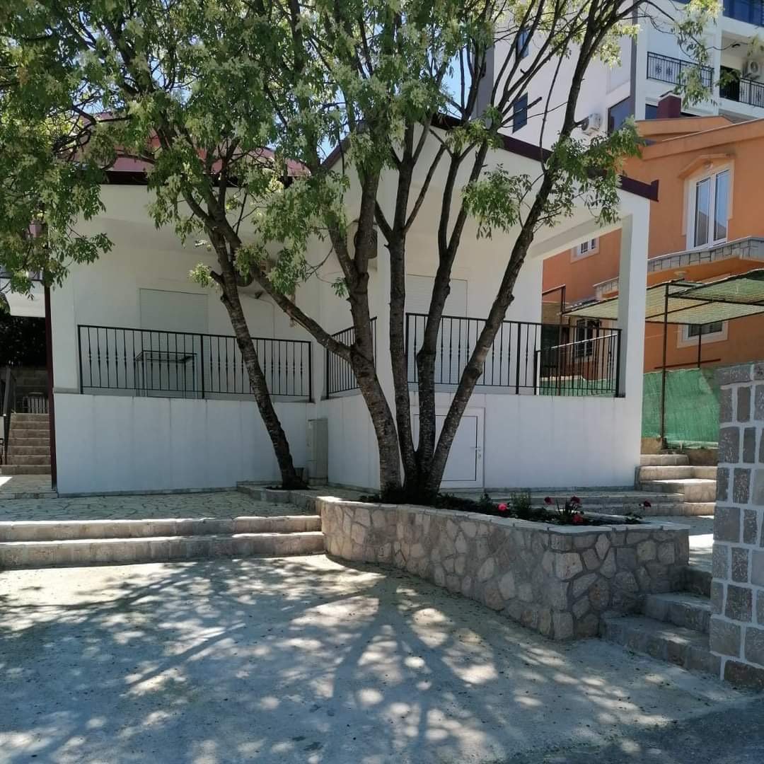 Modern white property with black railings, landscaped stone planter and trees in Ulcinj. Exclusive on immorenta.me by ekosphere doo.
