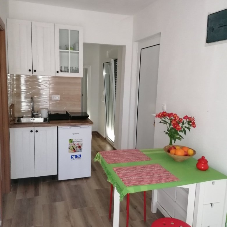 Modern Ulcinj apartment: bright kitchen with sleek white cabinets, quality finishes, and stylish accents&mdash;Ekosphere | immorenta.me.