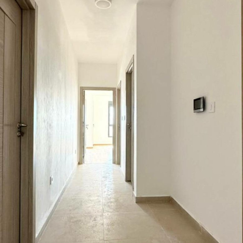Spacious hallway in Ekosphere DOO Ulcinj property&mdash;beige tiles, white walls, wood doors; bright, investment-ready. Montenegro-listings.me.