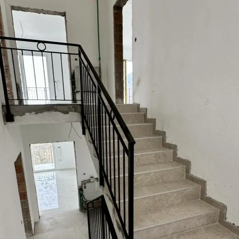 Modern stairway with beige steps and black railing in an Ulcinj property&acirc;prime investment from ekosphere doo via immorenta.me.
