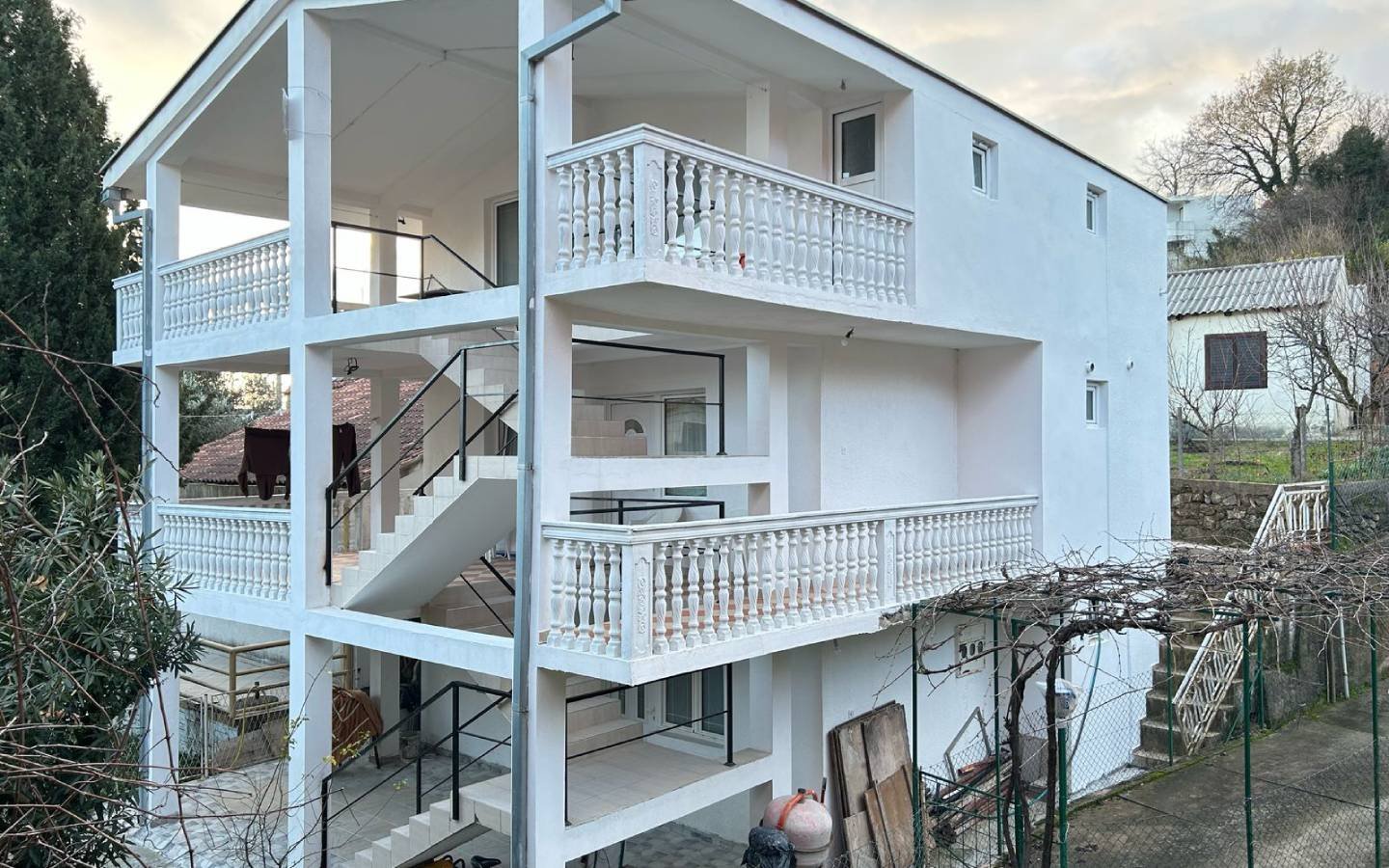 Modern three-story white home in Ulcinj, Montenegro with balconies and lush trees&mdash;exclusive listing on immorenta.me by ekosphere doo.