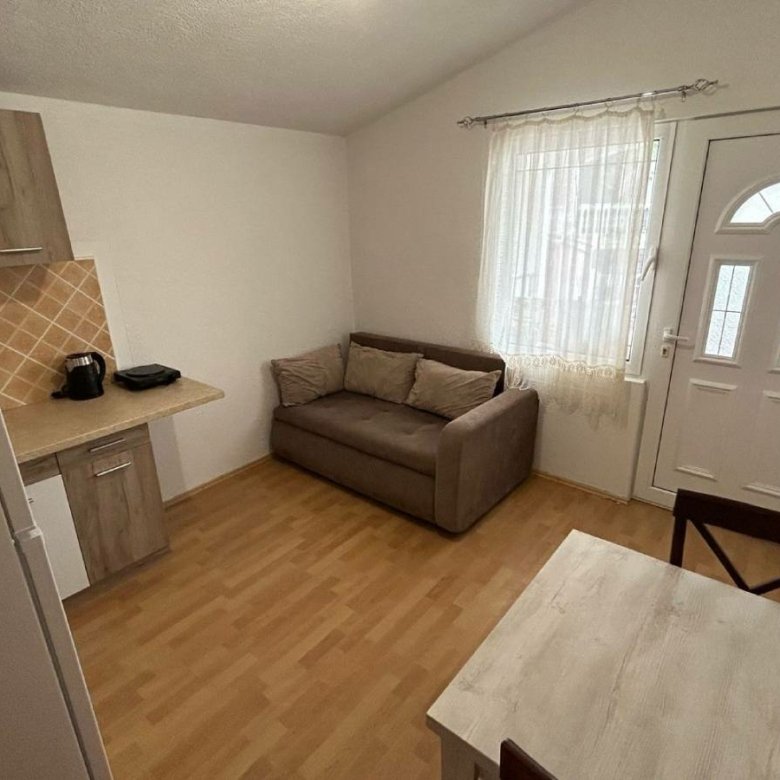 Modern Ulcinj studio with light wood floors, compact kitchen, and cozy furnishings&mdash;prime real estate via immorenta.me by ekosphere doo.