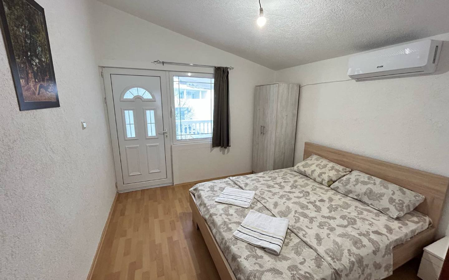 Charming Ulcinj bedroom for sale: double bed, AC, wardrobe, bright windows&mdash;prime Montenegro real estate via immorenta.me.