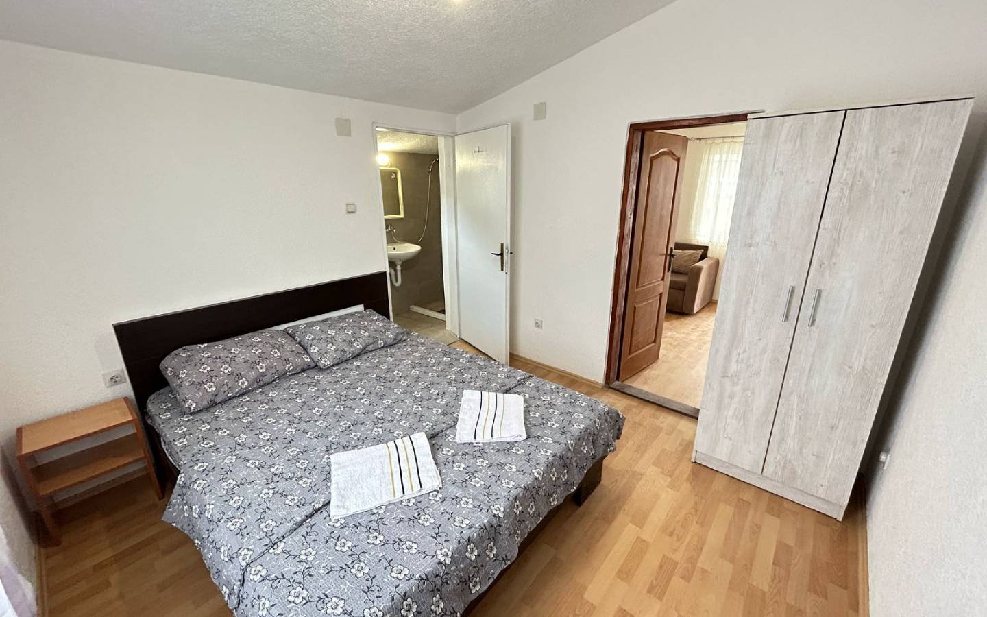 Elegant Ulcinj bedroom with floral double bed, ample storage, private bathroom; top investment on immorenta.me by Ekosphere.