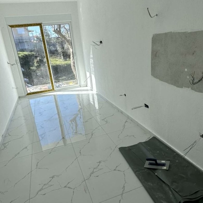 Renovation-ready room in Ulcinj, Montenegro; bright white walls, tiled flooring, glass doors&acirc;prime investment at immorenta.me by Ekosphere doo.