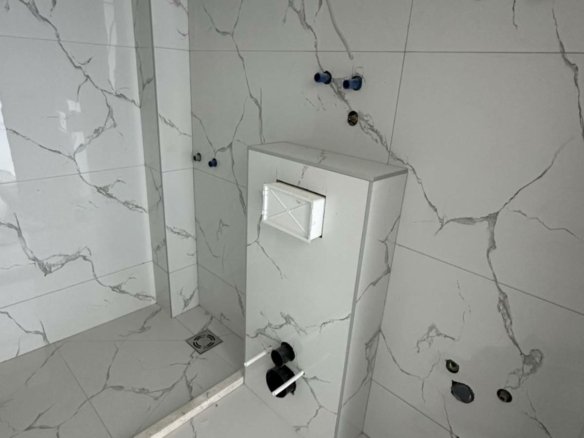 Badezimmer im Bau in Ulcinj mit eleganten Marmorfliesen, hochwertigen Armaturen - exklusive Immobilien von Ekosphere bei immorenta.me.