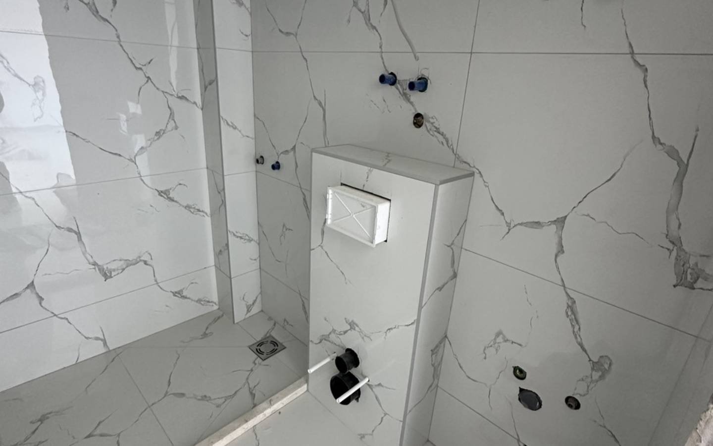 Badezimmer im Bau in Ulcinj mit eleganten Marmorfliesen, hochwertigen Armaturen - exklusive Immobilien von Ekosphere bei immorenta.me.