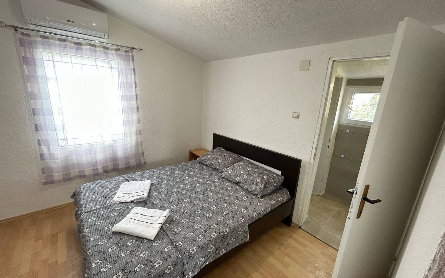 Modern Ulcinj bedroom with double bed, stylish wood floors, ensuite bath; top Montenegro investment on immorenta.me by Ekosphere.