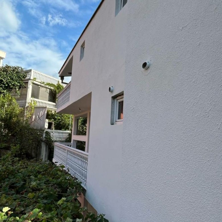 Modern white property in Ulcinj, Montenegro with balconies, security cameras, and lush greenery&mdash;exclusive on immorenta.me by Ekosphere doo.