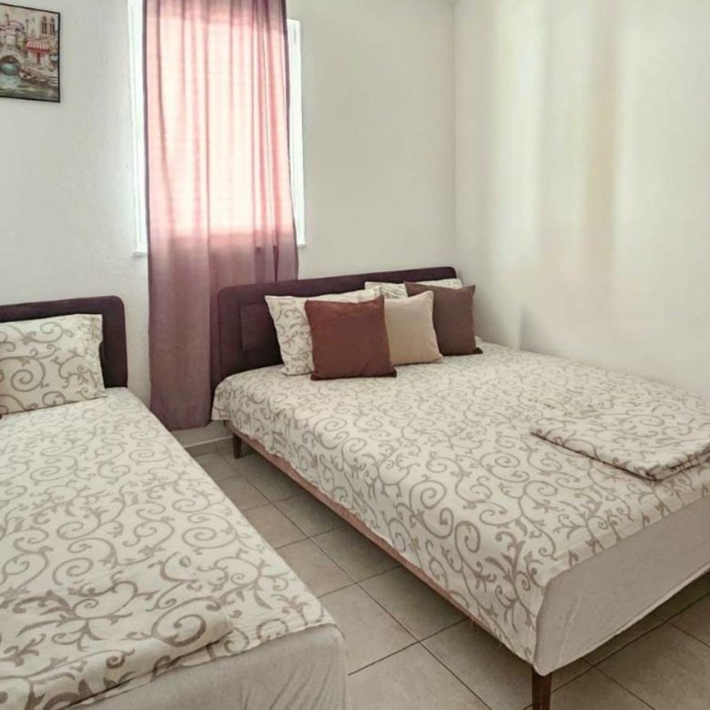 Stylish Ulcinj bedroom for sale: double & single beds, wood wardrobe, modern d&eacute;cor&mdash;prime real estate by immorenta.me/Ekosphere.