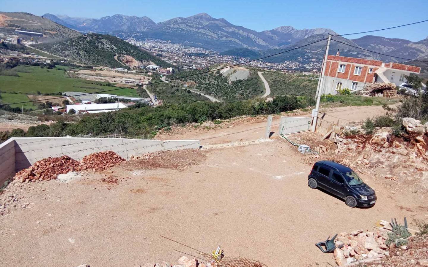 Prime Ulcinj, Montenegro investment: half-built home, gravel parking, mountain views. Listed by immorenta.me (ekosphere doo).