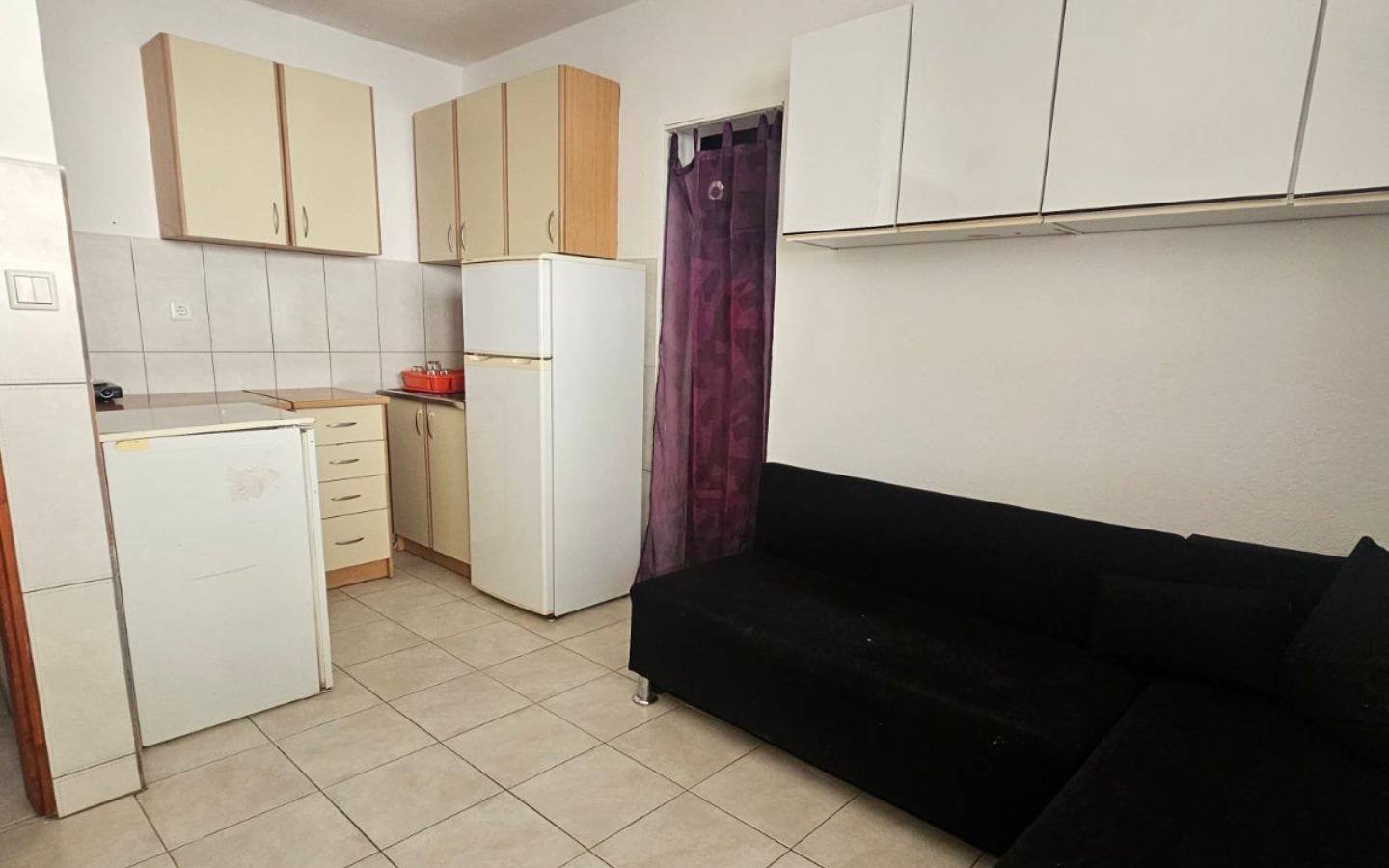 Modern Ulcinj apartment: light cabinets, tiled floors, L-shaped sofa. Invest in eco-friendly living&mdash;immorenta.me by ekosphere doo.