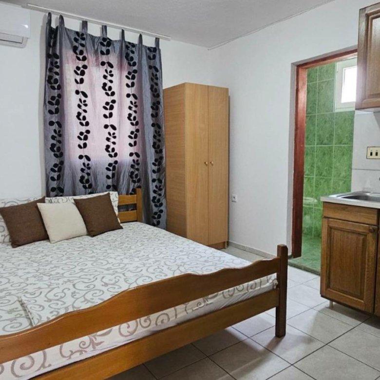 Modern Ulcinj studio: wooden bed, chic kitchenette, green-tiled bath. Smart eco-investment by Ekosphere on immorenta.me.