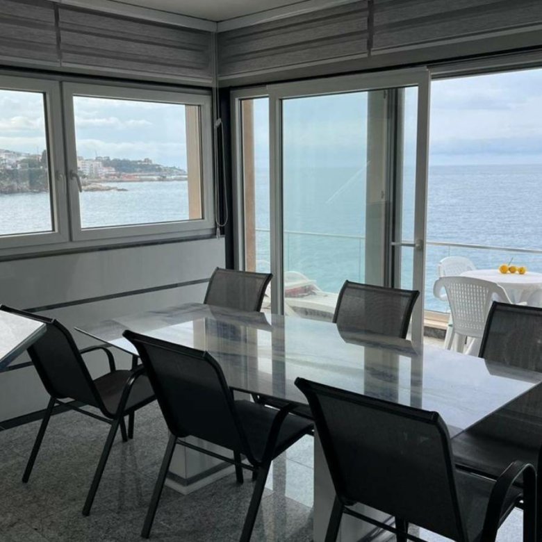 Elegant dining area with glass table, sea views, and modern design in Ulcinj&mdash;exclusive real estate from immorenta.me by Ekosphere.