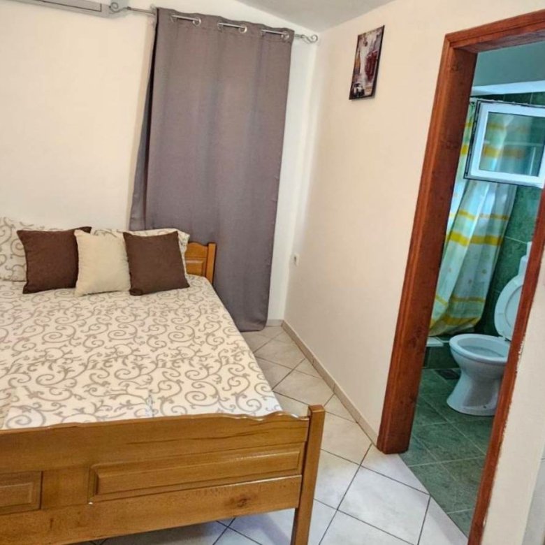 Modern Ulcinj Montenegro bedroom with stylish wooden bed, wardrobe, ensuite bath&mdash;ideal real estate investment by ekosphere doo.