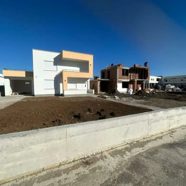Modern white-beige home beside a red brick build in Ulcinj, Montenegro&mdash;prime real estate by ekosphere doo on immorenta.me.