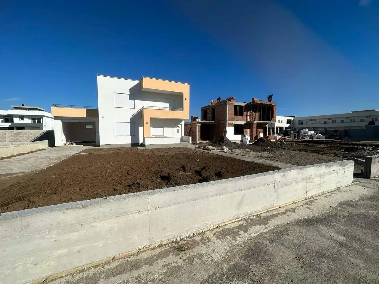 Modern white-beige home beside a red brick build in Ulcinj, Montenegro&mdash;prime real estate by ekosphere doo on immorenta.me.