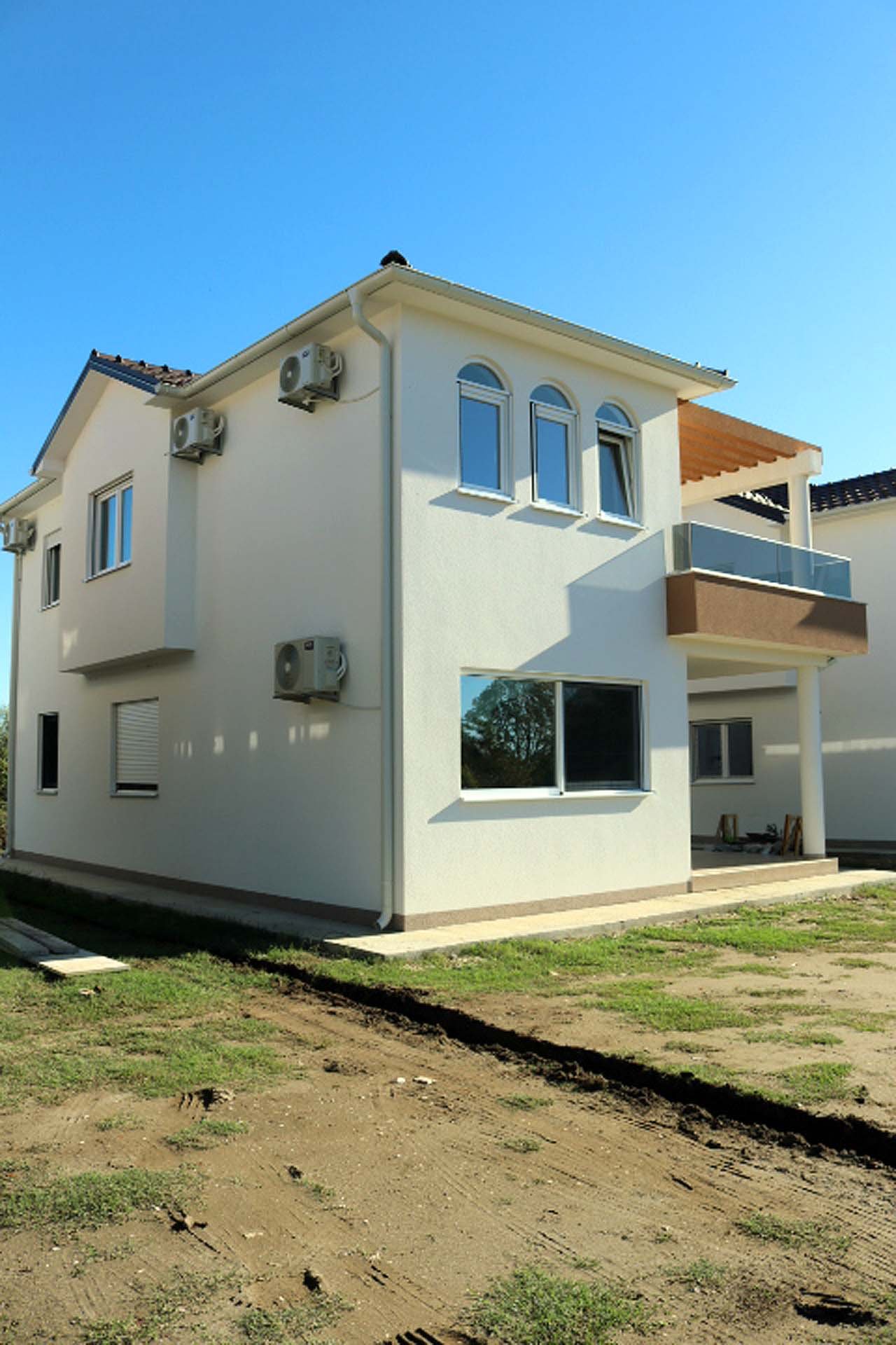 Elegant modern two-story villa in Ulcinj, Montenegro with white facade, glass balcony, A/C units; exclusive at immorenta.me by ekosphere doo. Elegant modern two-story villa in Ulcinj, Montenegro with white facade, glass balcony, A/C units; exclusive at immorenta.me by ekosphere doo.