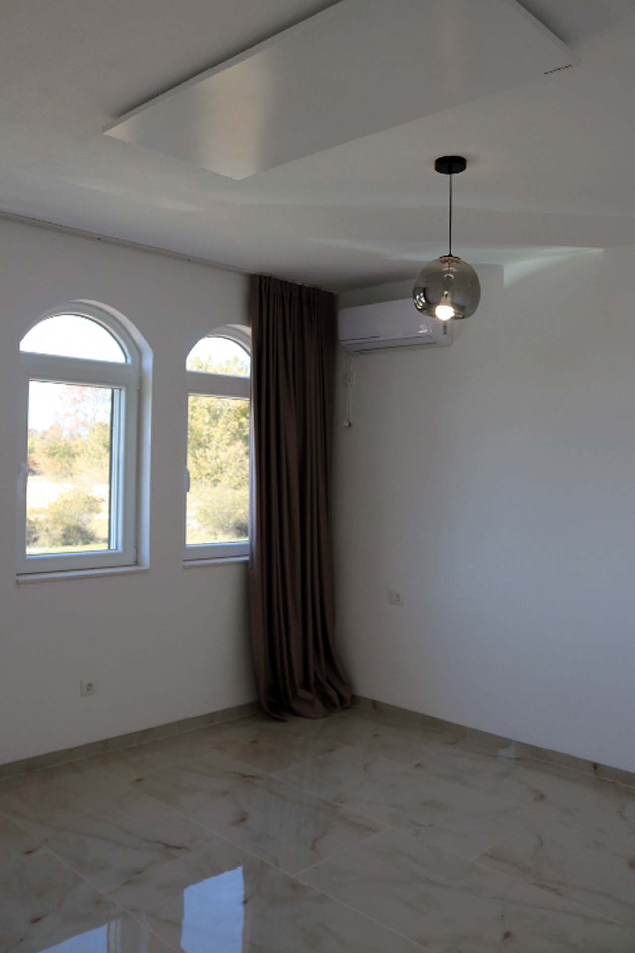 Spacious unfurnished room in Adana Villa, Ulcinj&mdash;white walls, tiled flooring, arched windows. Exclusive on immorenta.me.