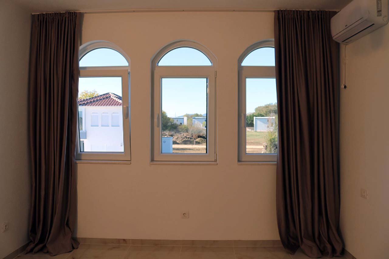Adana Villa in Ulcinj features elegant tall windows, luxe drapes, and AC&mdash;prime real estate at immorenta.me by ekosphere doo.