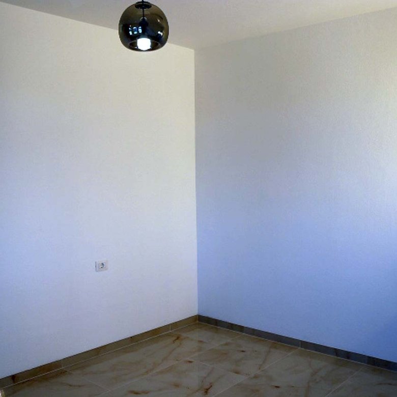 Bright, modern room in Adana Villa, Ulcinj&mdash;tile floors, white walls, natural light. Ideal Montenegro real estate by ekosphere doo.