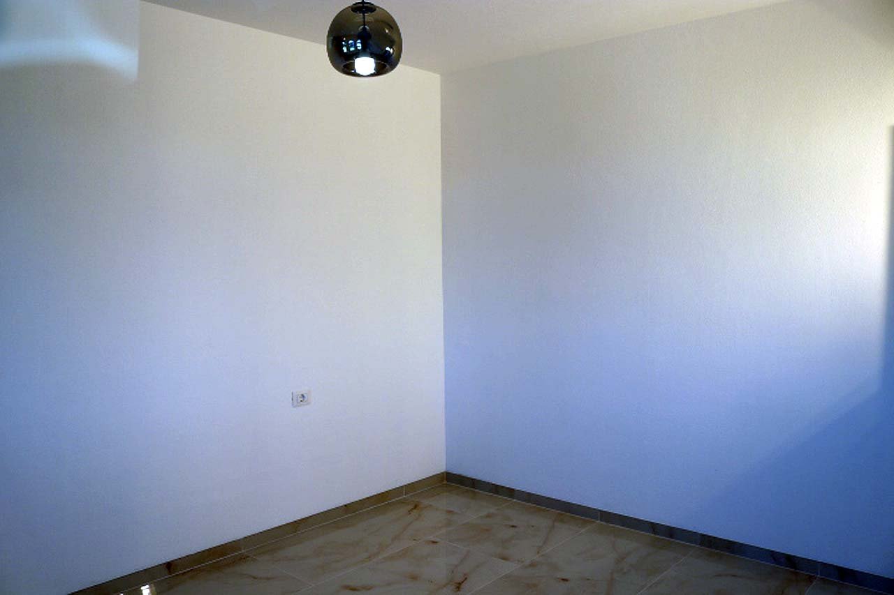 Bright, modern room in Adana Villa, Ulcinj&mdash;tile floors, white walls, natural light. Ideal Montenegro real estate by ekosphere doo.