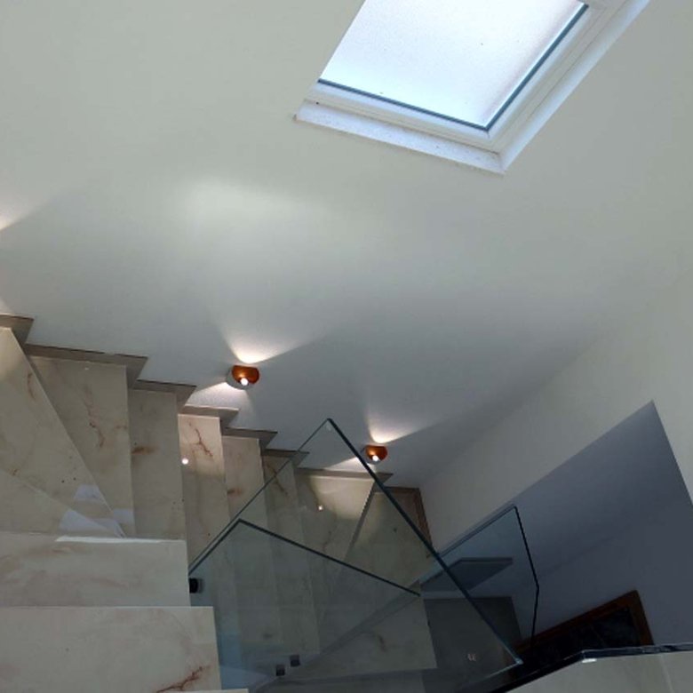 Elegant marble staircase with glass railing, skylight, and designer lighting&mdash;luxury Ulcinj villa investment via immorenta.me.